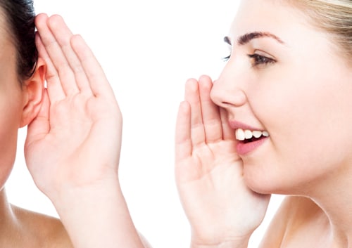 Close-up of young woman whispering playfully